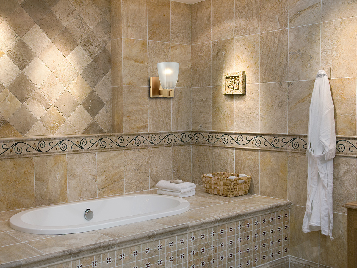 bathtub with wall sconce above it